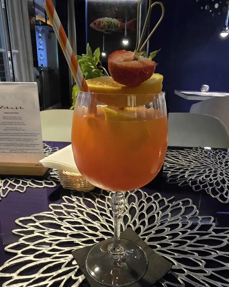 Kolorowy drink z owocami na koronkowej podkładce