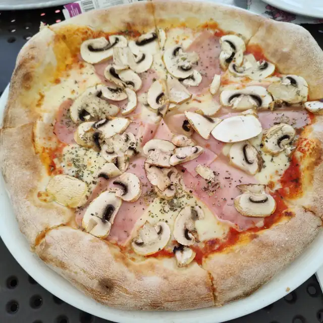 Pizza z szynką i pieczarkami na cienkim cieście